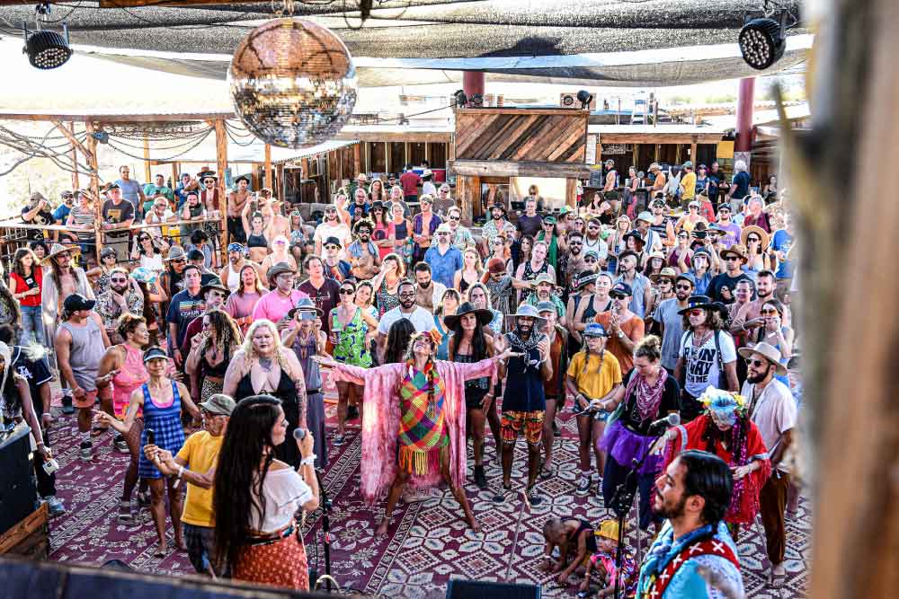 people dancing joyously under a giant disco ball at the Joshua Tree Music Festival, Joshua Tree, CA